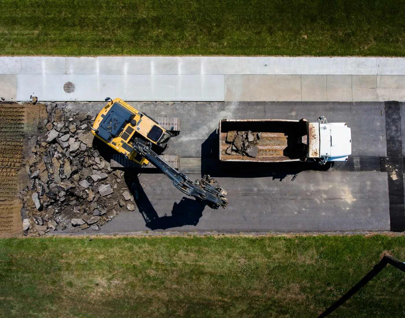 Overhead view of an excavator beside a truck
