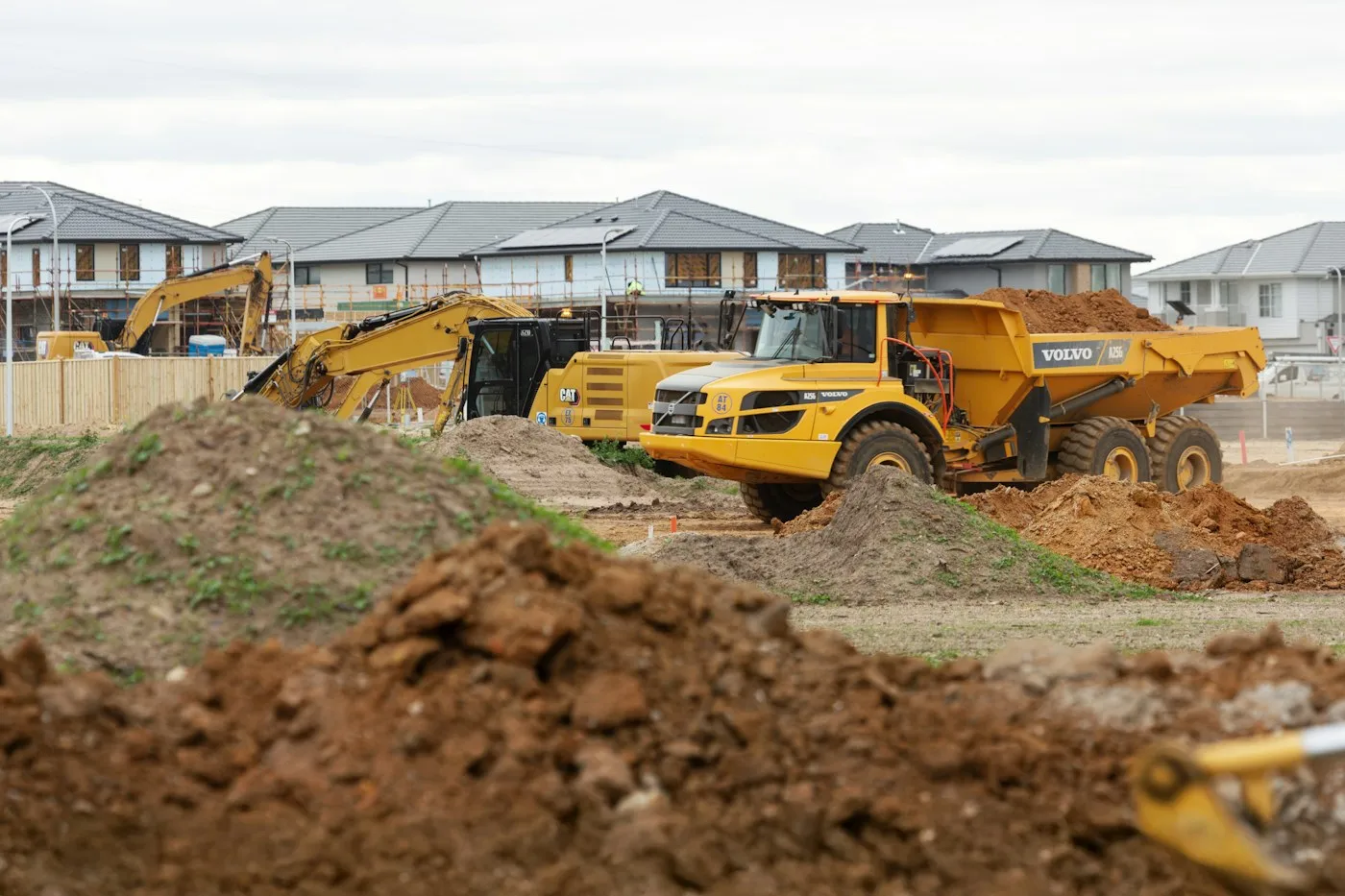 Excavator and dump truck handling soil